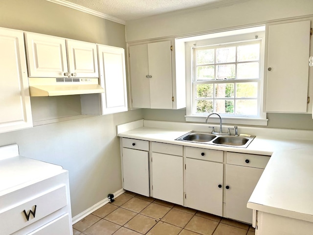 kitchen with sink, ornamental molding, a textured ceiling, white cabinets, and light tile patterned flooring