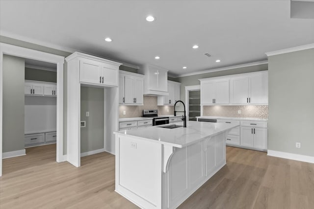 195 County Road 711, Enterprise, AL 36330 - kitchen featuring a sink, electric range, a center island with sink, ornamental molding, and white cabinetry