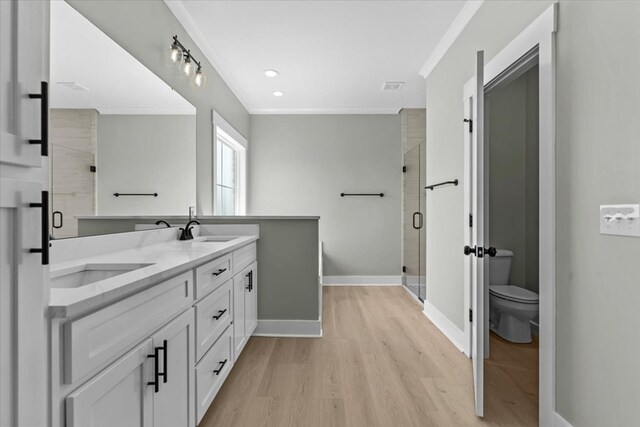 195 County Road 711, Enterprise, AL 36330 - full bath featuring wood finished floors, a shower stall, ornamental molding, double vanity, and toilet