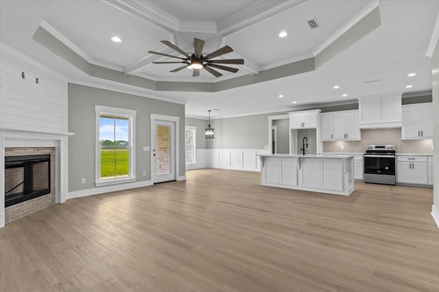 195 County Road 711, Enterprise, AL 36330 - unfurnished living room with ornamental molding, a large fireplace, ceiling fan, coffered ceiling, and light wood-style floors