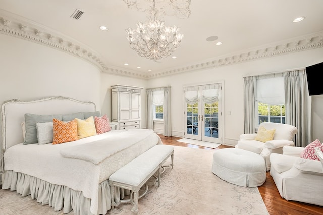 bedroom with access to outside, french doors, hardwood / wood-style flooring, ornamental molding, and a chandelier