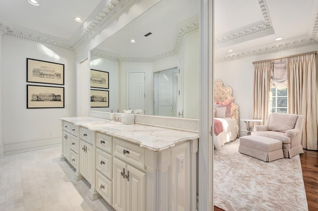 bathroom featuring a raised ceiling, vanity, wood-type flooring, and ornamental molding