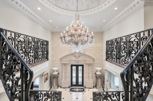 foyer featuring a towering ceiling and ornamental molding