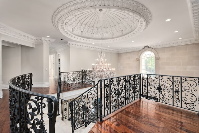 corridor featuring hardwood / wood-style floors, crown molding, and a tray ceiling