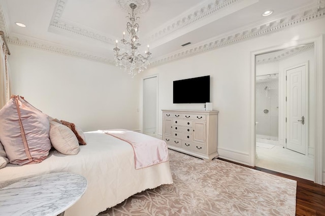 bedroom with ensuite bathroom, ornamental molding, a tray ceiling, a chandelier, and light hardwood / wood-style floors