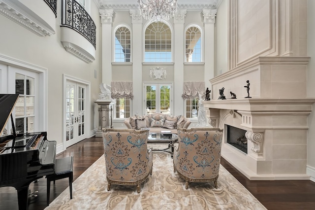 living room with a notable chandelier, dark hardwood / wood-style flooring, a high ceiling, and french doors