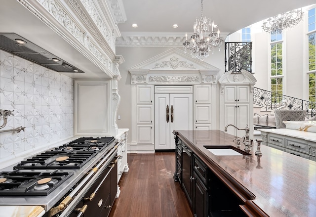 kitchen with sink, dark wood-type flooring, stainless steel gas cooktop, crown molding, and decorative backsplash