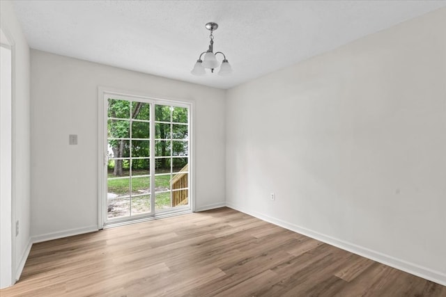 618 Langley Dr, Dothan, AL 36301 - empty room with a chandelier, light wood finished floors, baseboards, and a textured ceiling