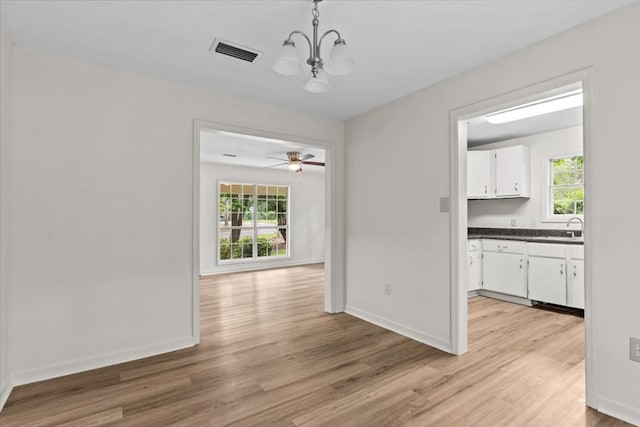 618 Langley Dr, Dothan, AL 36301 - empty room with light wood-style flooring, a sink, baseboards, ceiling fan, and a chandelier