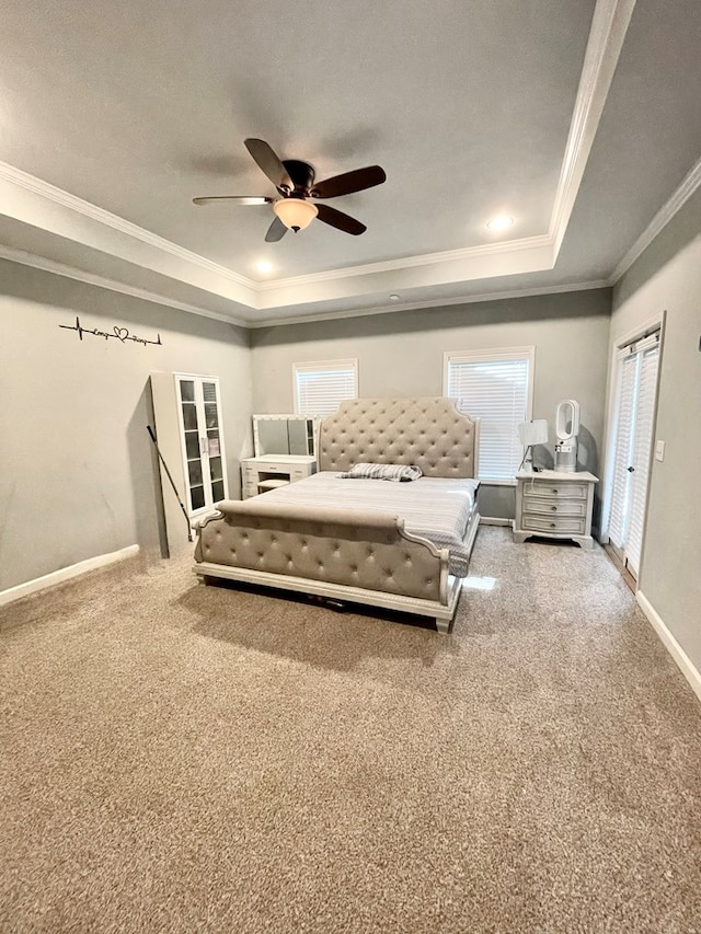 unfurnished bedroom with a tray ceiling, baseboards, carpet floors, and crown molding