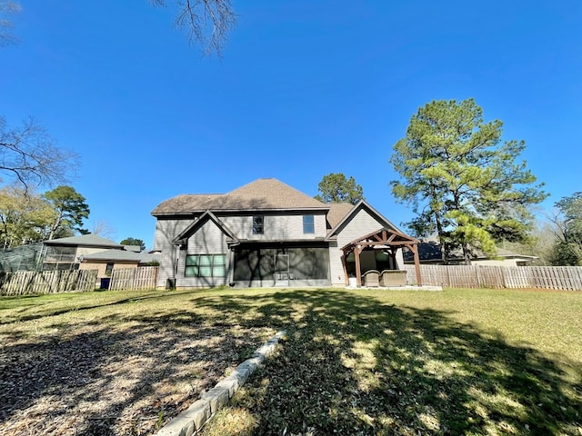 rear view of property with a patio area, a yard, a fenced backyard, and a sunroom