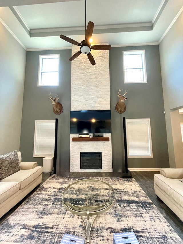 living area with visible vents, plenty of natural light, a fireplace, and crown molding