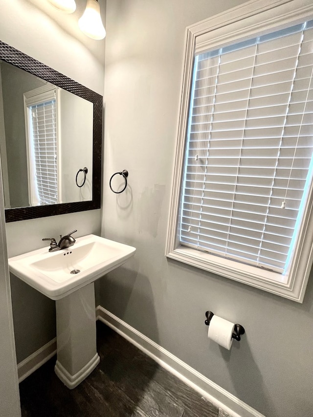 bathroom with wood finished floors, baseboards, and a sink