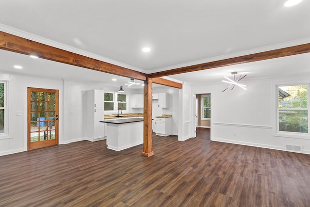 unfurnished living room featuring ornamental molding, dark wood-type flooring, a healthy amount of sunlight, and sink