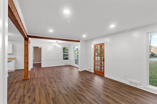 unfurnished living room featuring dark hardwood / wood-style floors, plenty of natural light, and ornamental molding