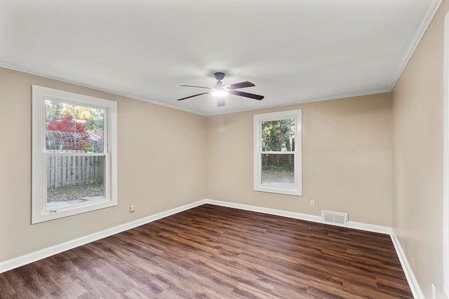 empty room featuring ceiling fan, ornamental molding, dark wood-type flooring, and a wealth of natural light