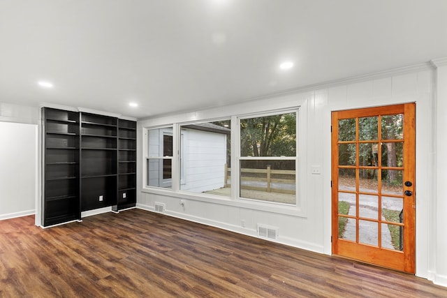 empty room featuring crown molding and dark hardwood / wood-style flooring