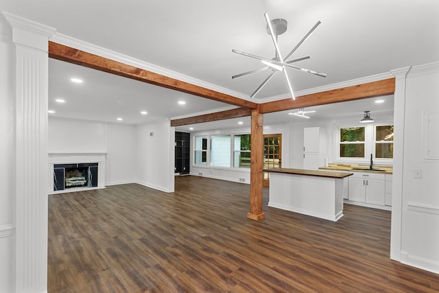 unfurnished living room with dark hardwood / wood-style flooring, a wealth of natural light, and a notable chandelier