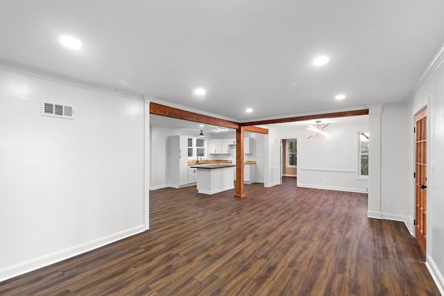 unfurnished living room with crown molding and dark wood-type flooring