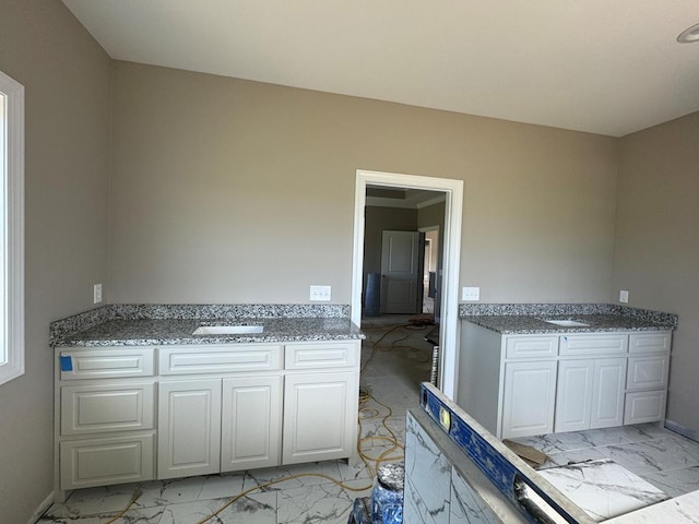 interior space with stone counters and white cabinetry