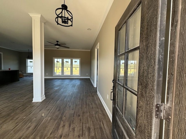 hallway featuring a chandelier, ornamental molding, ornate columns, and dark wood-type flooring