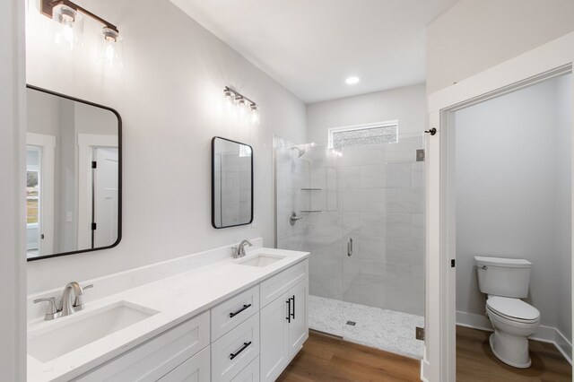 bathroom featuring vanity, wood-type flooring, toilet, and walk in shower