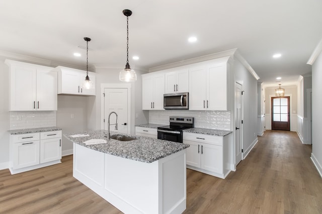 kitchen with light stone counters, stainless steel appliances, sink, and white cabinets