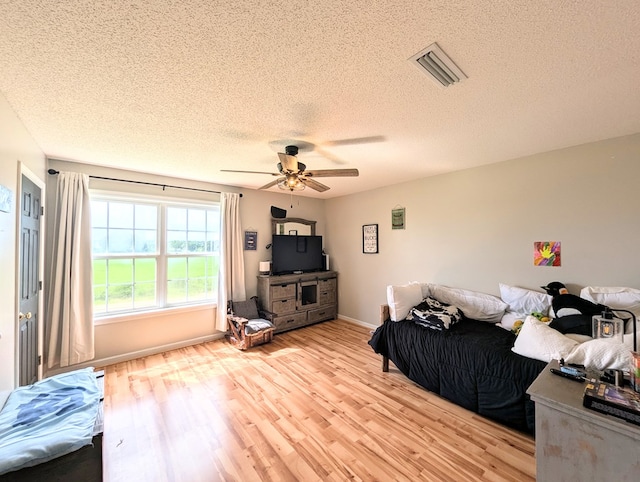 1370 Coach Rd, Slocomb, AL 36375 - living area with light wood-style flooring, a textured ceiling, and a ceiling fan