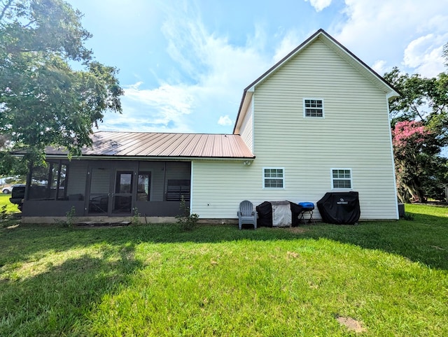 1370 Coach Rd, Slocomb, AL 36375 - back of house with a sunroom, a lawn, and a metal roof