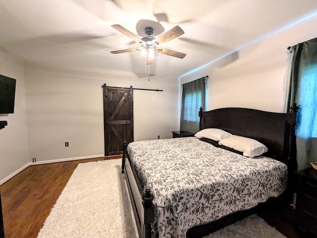 1370 Coach Rd, Slocomb, AL 36375 - bedroom featuring a barn door, wood finished floors, and ceiling fan