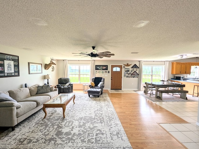 1370 Coach Rd, Slocomb, AL 36375 - living room featuring a textured ceiling, a ceiling fan, and light wood finished floors