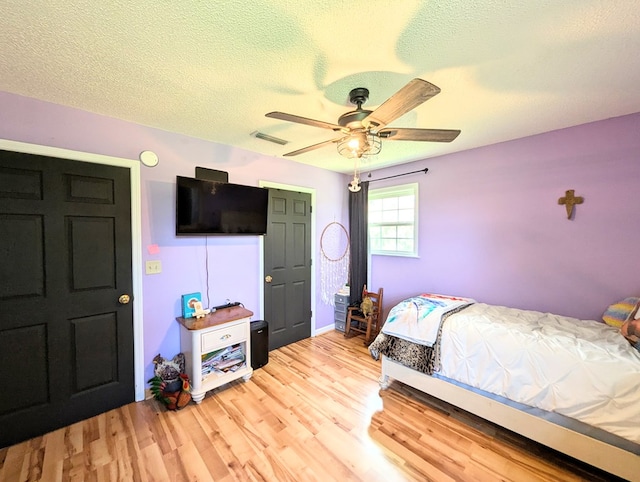 1370 Coach Rd, Slocomb, AL 36375 - bedroom with light wood-style floors, a textured ceiling, and a ceiling fan