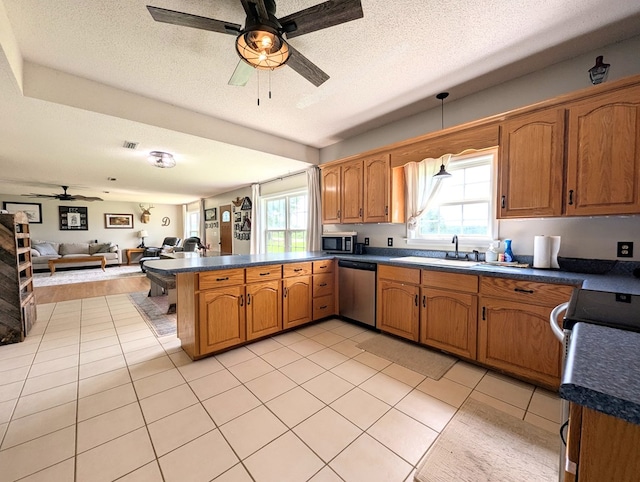 1370 Coach Rd, Slocomb, AL 36375 - kitchen with appliances with stainless steel finishes, a ceiling fan, a peninsula, dark countertops, and open floor plan