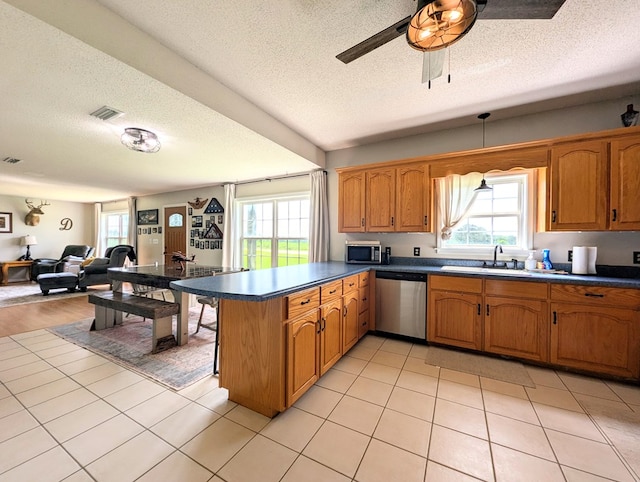 1370 Coach Rd, Slocomb, AL 36375 - kitchen with appliances with stainless steel finishes, a textured ceiling, a peninsula, healthy amount of natural light, and open floor plan