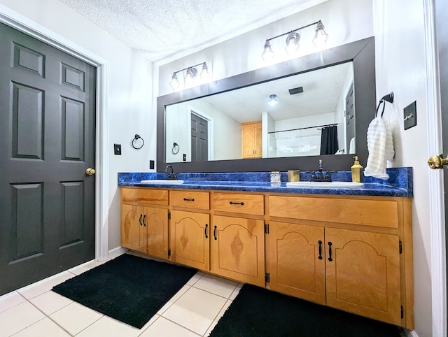1370 Coach Rd, Slocomb, AL 36375 - bathroom featuring double vanity, a textured ceiling, and tile patterned flooring