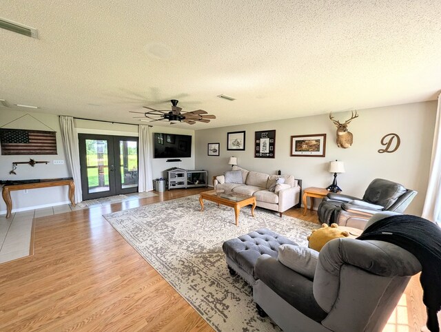 1370 Coach Rd, Slocomb, AL 36375 - living area featuring a textured ceiling, french doors, light wood-style flooring, and a ceiling fan