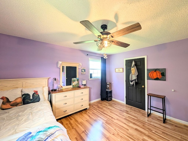 1370 Coach Rd, Slocomb, AL 36375 - bedroom with a textured ceiling, light wood-style floors, and ceiling fan