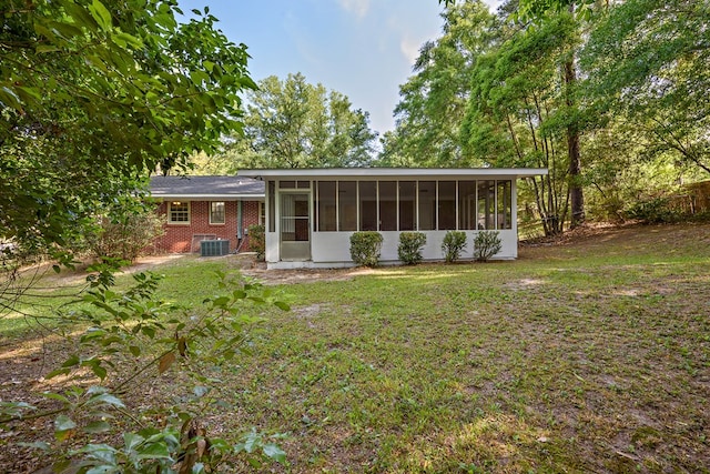 139 Merrydell Dr, Ozark, AL 36360 - rear view of property with a sunroom, a yard, and brick siding