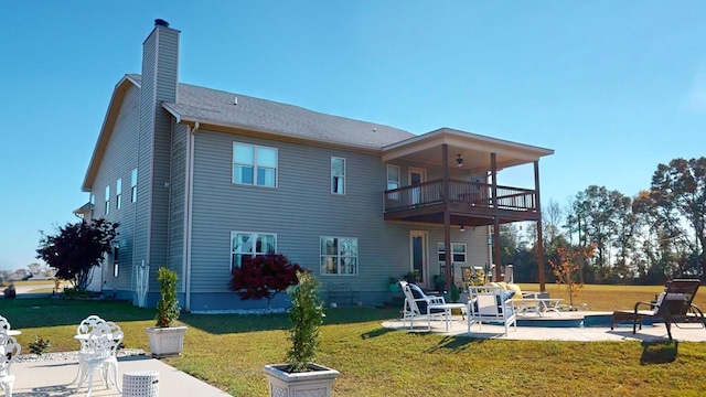 back of house with a yard, a patio, and a balcony