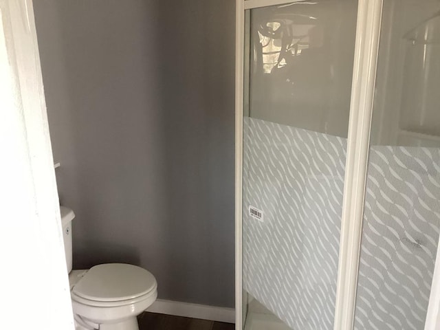 bathroom featuring a shower and toilet