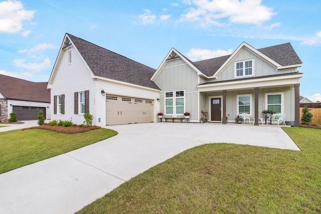 view of front facade featuring covered porch, a garage, and a front yard