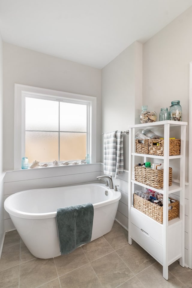 bathroom with tile patterned floors and a washtub