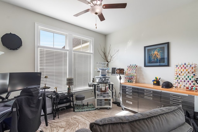 carpeted home office featuring ceiling fan