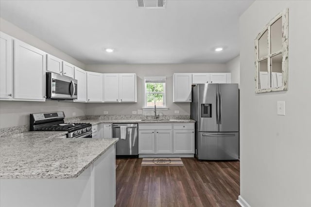 630 Ridgeland Rd, Dothan, AL 36301 - kitchen featuring stainless steel appliances, white cabinets, dark wood finished floors, a peninsula, and recessed lighting