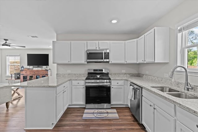 630 Ridgeland Rd, Dothan, AL 36301 - kitchen featuring stainless steel appliances, a peninsula, white cabinetry, light stone counters, and recessed lighting