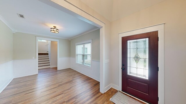 entrance foyer with ornamental molding and hardwood / wood-style flooring