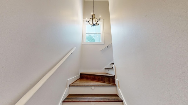 stairway with a notable chandelier