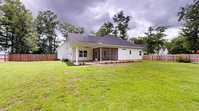 rear view of house with ceiling fan, a yard, and a patio