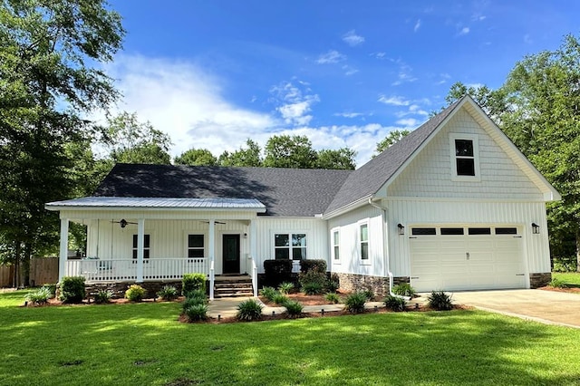 view of front of home with a garage, covered porch, and a front yard