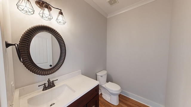 bathroom featuring vanity, hardwood / wood-style flooring, toilet, and ornamental molding